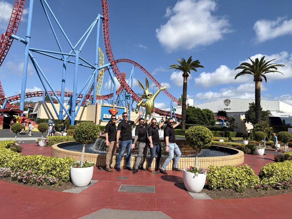 The grolife team by the fountain in front of the roller coasters at Movie World